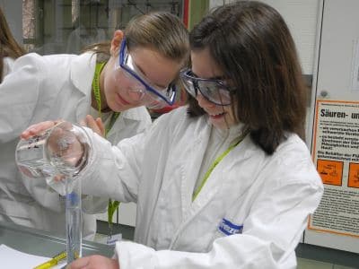 Zwei Mädchen im Labor mit Reagenzglas
