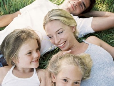 Ein junger Mann, eine junge Frau und zwei kleine Kinder liegen im Gras.