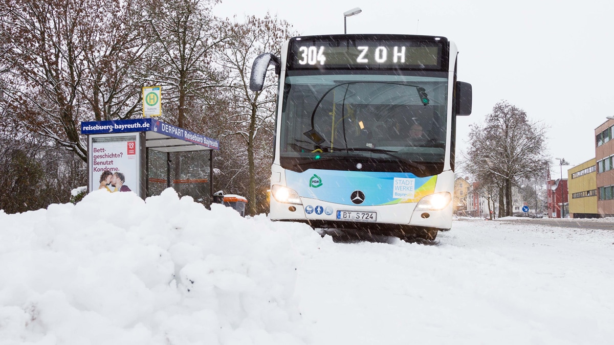 Stadtbus auf schneebedeckter Straße.