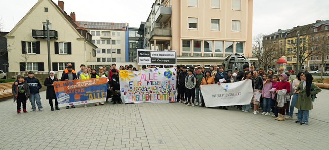 Eine Schülergruppe demonstriert auf einem Platz und hält Plakate in der Hand.